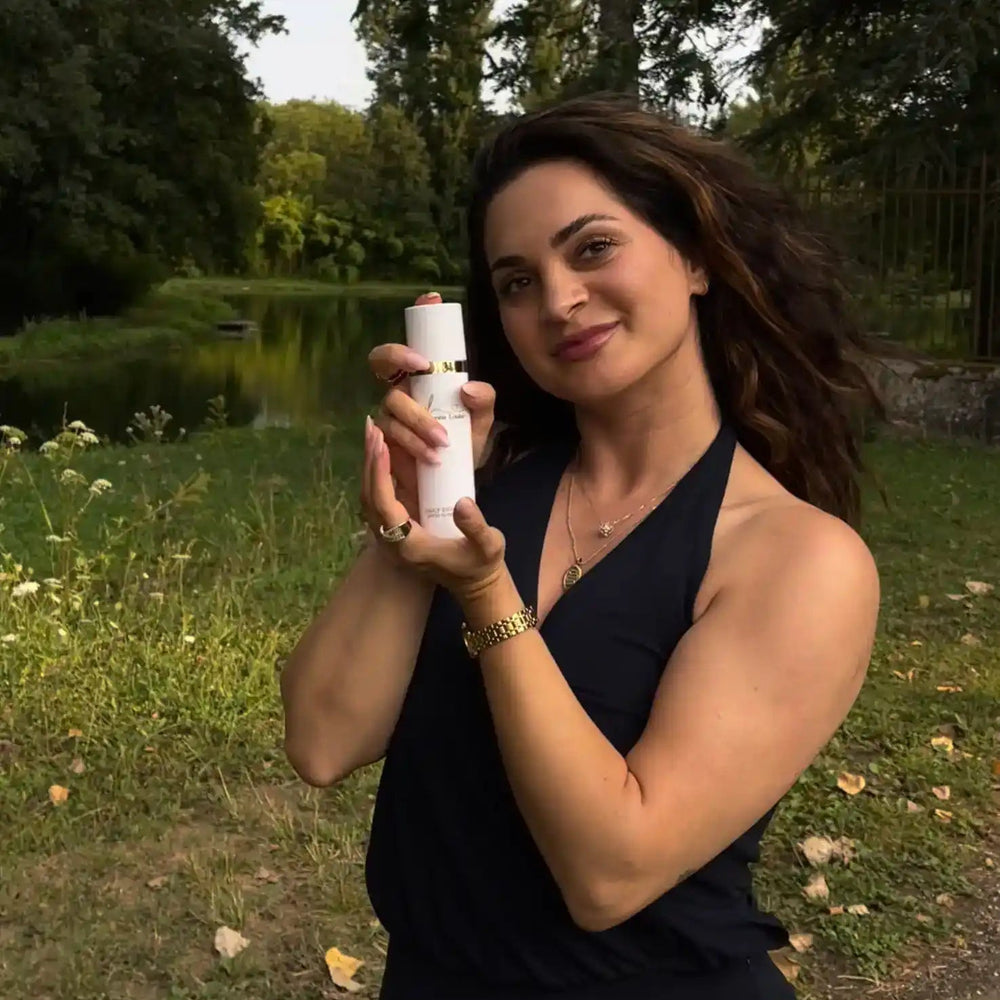 Vrouw in buitenomgeving toont luxe gezichtsverzorging zonder parabenen, ontwikkeld door schoonheidsspecialiste.
