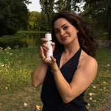 Vrouw in buitenomgeving toont luxe gezichtsverzorging zonder parabenen, ontwikkeld door schoonheidsspecialiste.